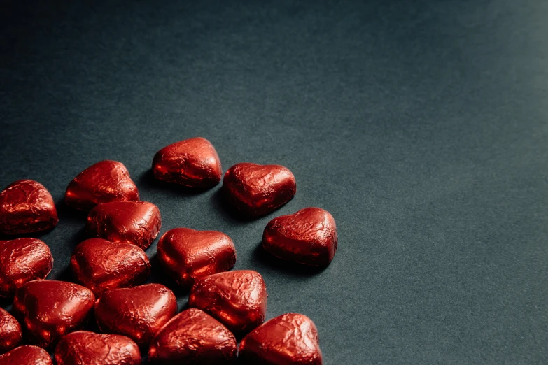 a pile of chocolate hearts sitting on top of a table, pexels, romanticism, metallic red, slate, thumbnail, cinamtic