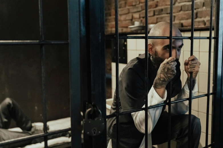 a man is sitting in a jail cell, inspired by Elsa Bleda, pexels contest winner, peaky blinders, bald male swashbuckler, zayn malik, thumbnail