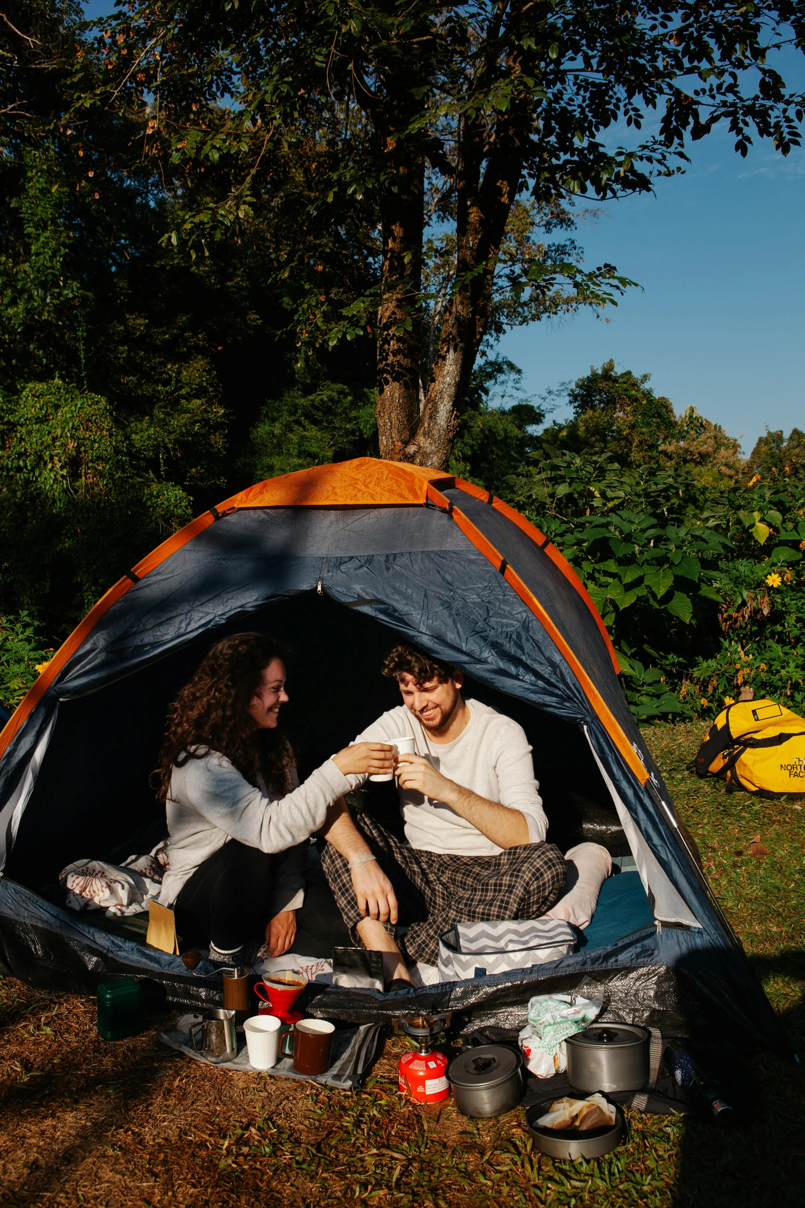 a couple of people sitting inside of a tent, in the garden