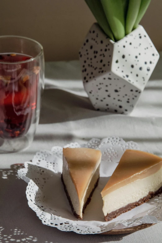 a slice of cheesecake on a plate next to a cup of tea, a still life, unsplash, made of glazed, drink, silk, julia hetta