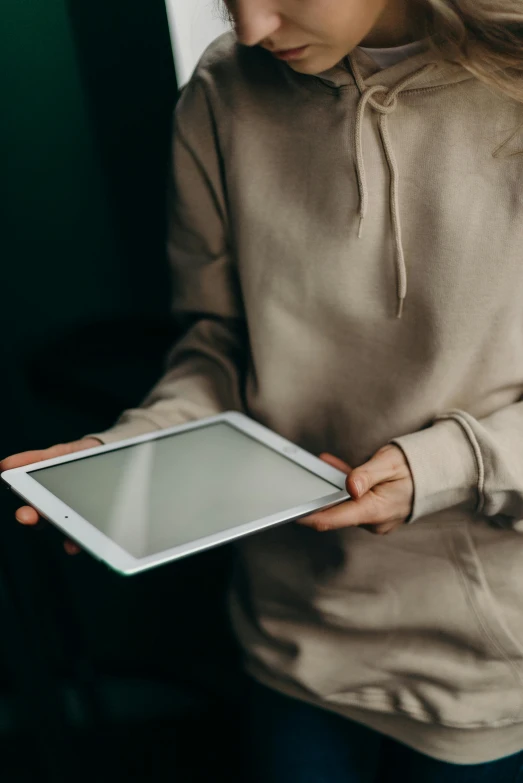 a woman holding a tablet computer in her hands, by Carey Morris, trending on pexels, thin young male, wearing a light shirt, taken in 2 0 2 0, panel