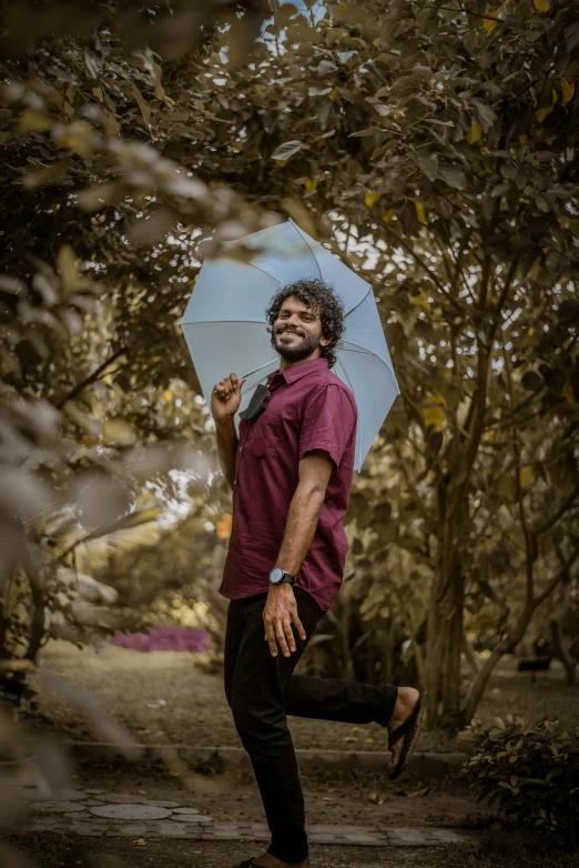 a man standing in the middle of a forest holding an umbrella, an album cover, pexels contest winner, vinayak, smiling male, sassy pose, colored photo