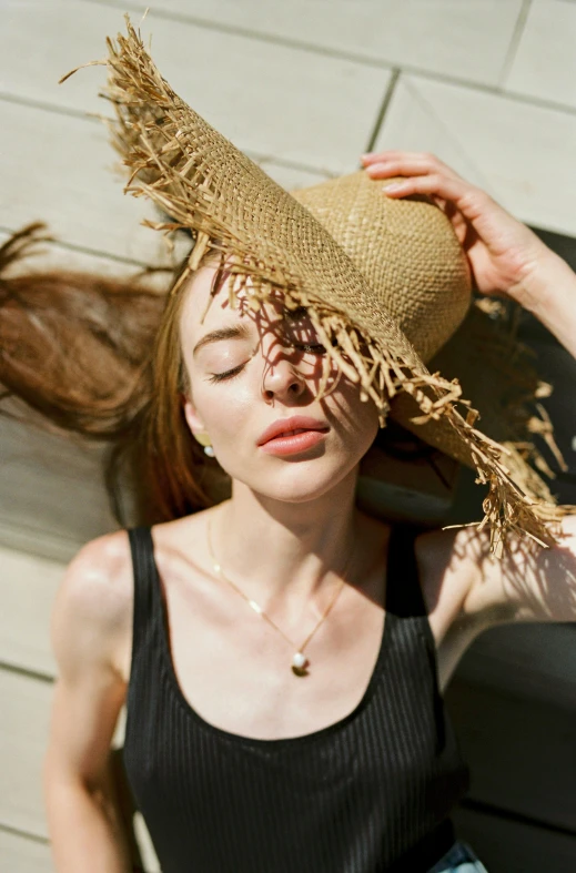 a woman with her eyes closed wearing a straw hat, by Anna Boch, trending on pexels, renaissance, kiko mizuhara, brown fringe, pale skin!, sun overhead