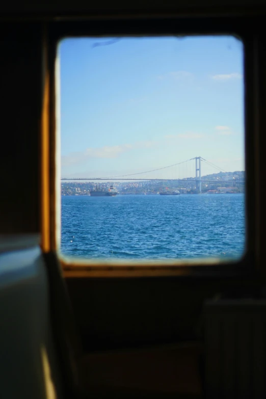 a large body of water with a bridge in the distance, by Niyazi Selimoglu, happening, inside the train, istanbul, slide show, cinematic shot ar 9:16 -n 6 -g