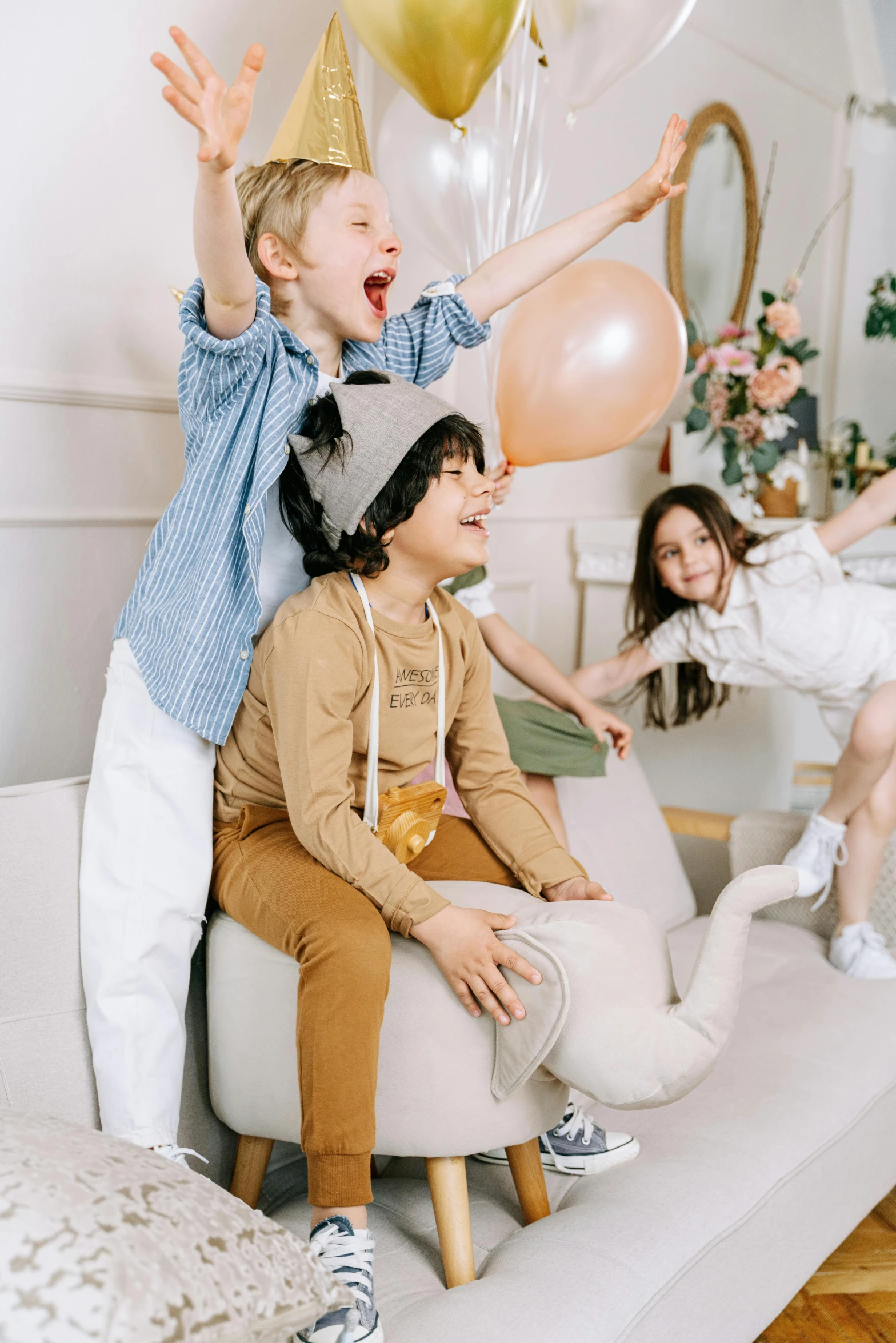 a group of children sitting on top of a couch, holding a balloon, beige fedora, curated collections, playing