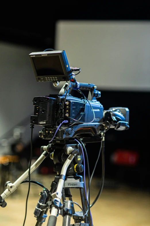 a close up of a camera on a tripod, video art, tv studio, pictured from the shoulders up, theatre equipment, tv program