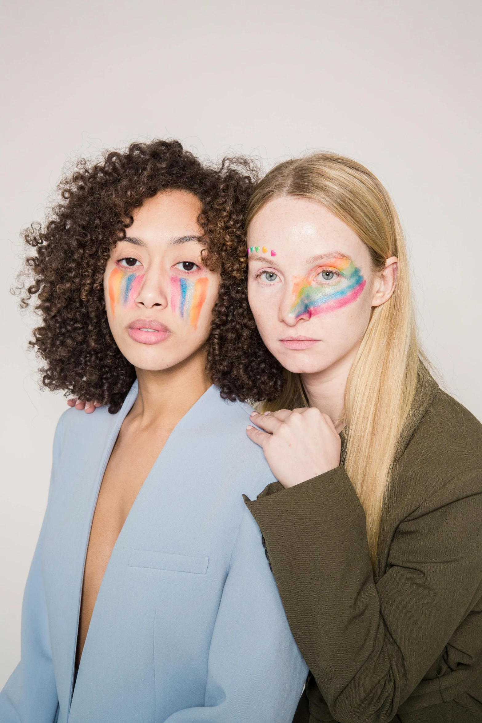 two women with face paint on their faces, an album cover, inspired by Okuda Gensō, trending on pexels, renaissance, light skin, transparent, stripe over eye, model pose