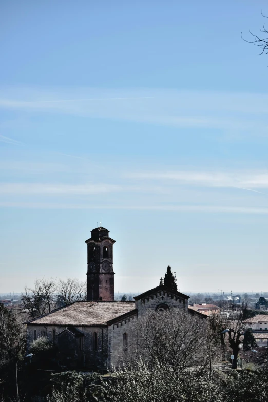 a large building with a clock tower on top of it, a picture, inspired by Bernardo Bellotto, romanesque, shot from far away, winter sun, churches, visible from afar!!