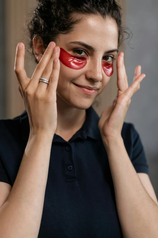 a woman with a red eye patch on her face, by Julia Pishtar, trending on pexels, partially cupping her hands, marked muscles, circular glasses, technical