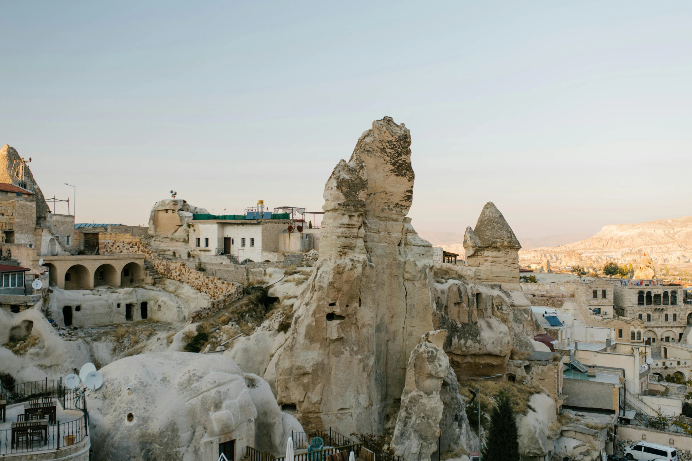 a group of people standing on top of a mountain, a marble sculpture, whitewashed buildings, caves, exterior photo, travel guide