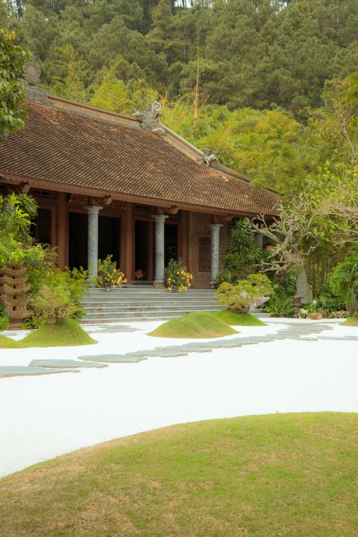 a house sitting in the middle of a lush green forest, inspired by Saneatsu Mushanokōji, white sand, driveway, square, vietnam