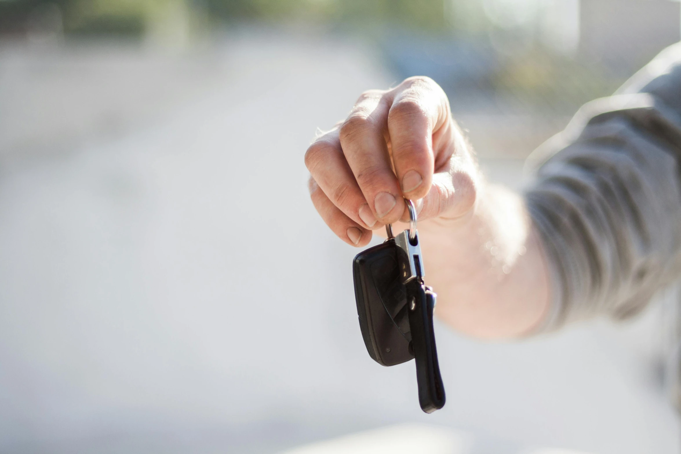 a close up of a person holding a car key, by Will Ellis, square, contain, former