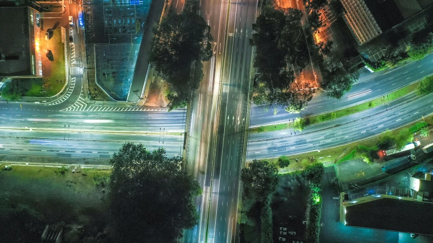 an aerial view of a city at night, unsplash contest winner, digital art, accurate roads, intersection, city lights made of lush trees, 2000s photo
