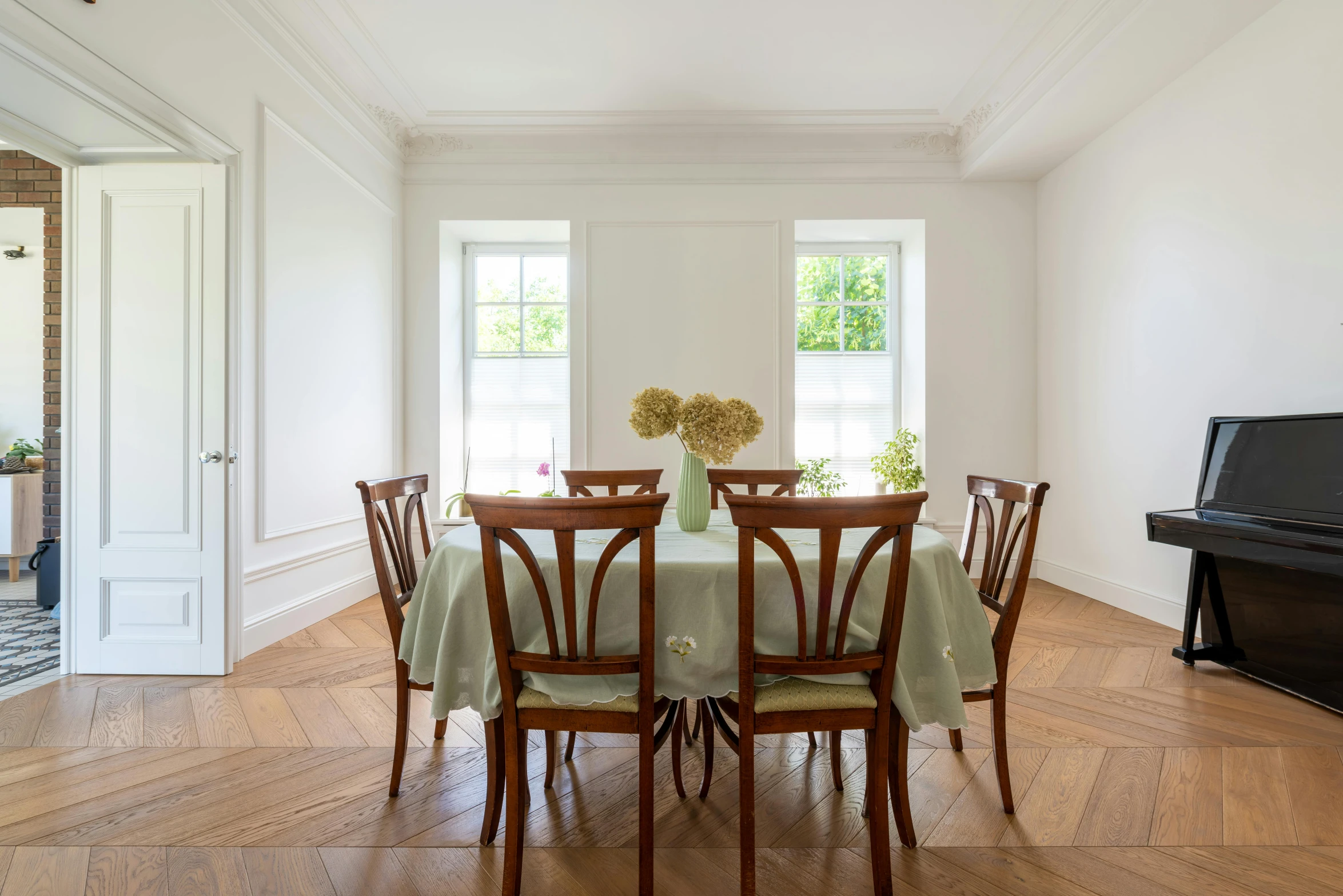 a dining room with a table and four chairs, inspired by Wilhelm Hammershøi, unsplash, baroque, big french door window, bright castleton green, tablecloth, sitting in an empty white room