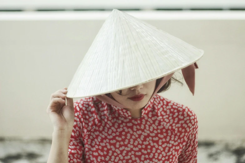 a woman in a red dress and a white hat, inspired by Tan Ting-pho, trending on unsplash, pointy conical hat, with a covered face, vietnamese woman, dezeen