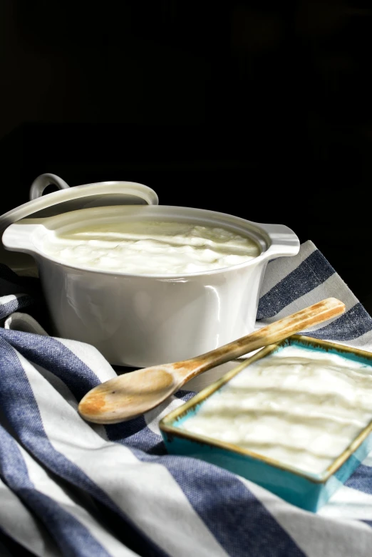 a bowl of yogurt sitting on top of a table, square, linen, churning, good soup