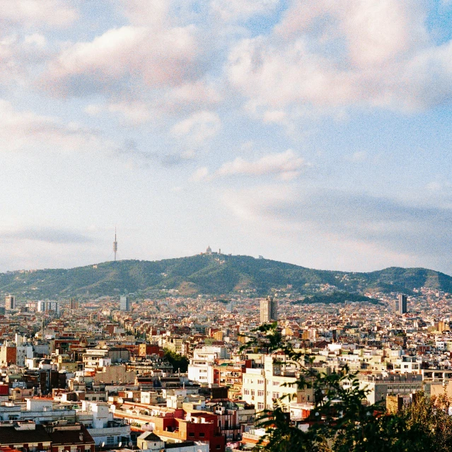 a view of a city from the top of a hill, inspired by Modest Urgell, pexels contest winner, kodak portra film, fc barcelona, frank gehry, two mountains in background