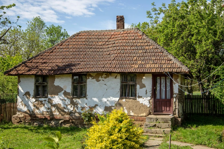 a small white house with a brown roof, by Adam Marczyński, pixabay contest winner, deteriorated, dezeen, ecovillage, exterior photo