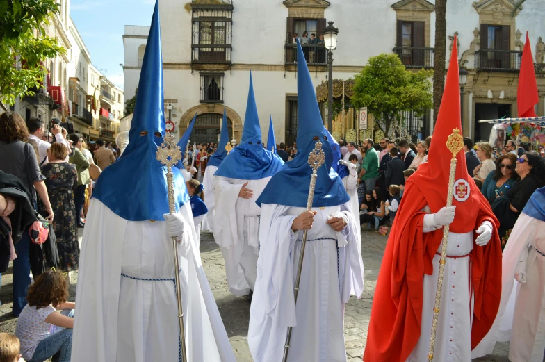 a group of people dressed in costume walking down a street, by Juan Giménez, pexels contest winner, the three marys at the sepulchre, white and blue, square, los carpinteros