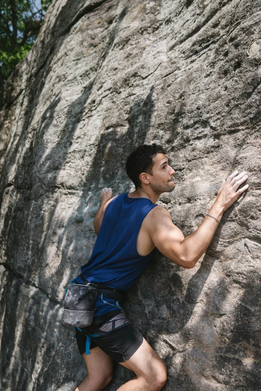 a man climbing up the side of a rock, pexels contest winner, renaissance, wearing a tanktop, 30 year old man :: athletic, arched back, florida man