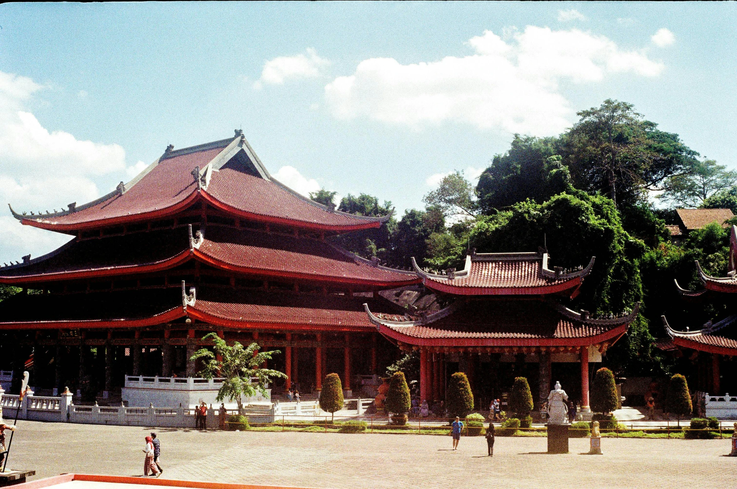 a group of people standing in front of a building, pagoda, red roofs, coban, large hall