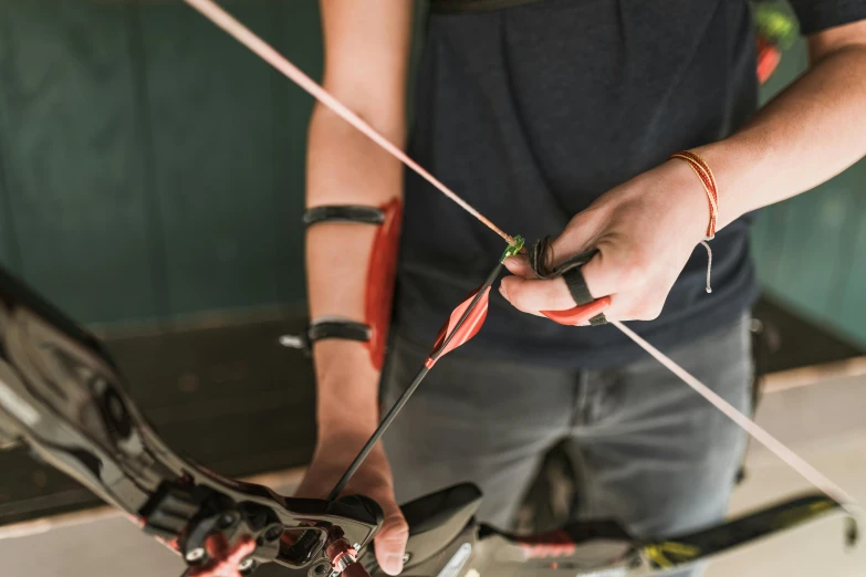 a close up of a person holding a bow and arrow, profile image, maintenance photo, rectangle, webbing