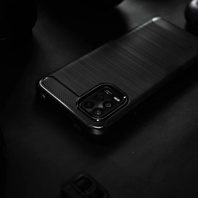 a close up of a cell phone on a table, a picture, by Mathias Kollros, pexels contest winner, realism, all black matte product, cell cover style, carbon fibers, background image