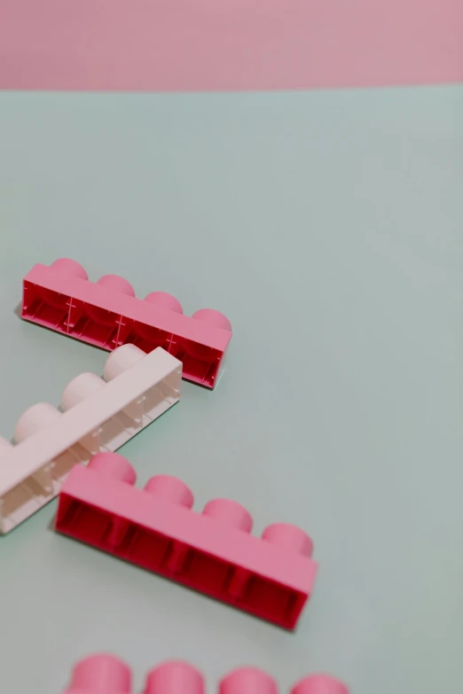 a bunch of pink legos sitting on top of a table, inspired by Frederick Hammersley, pexels contest winner, plasticien, bridges, profile, cream, reds