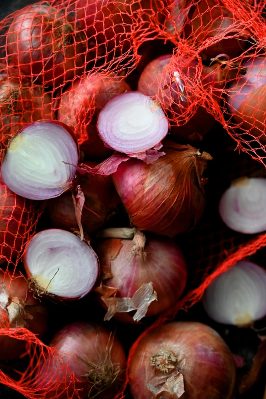 a bag of onions sitting on top of a table, red mesh in the facede, slide show, piled around, square