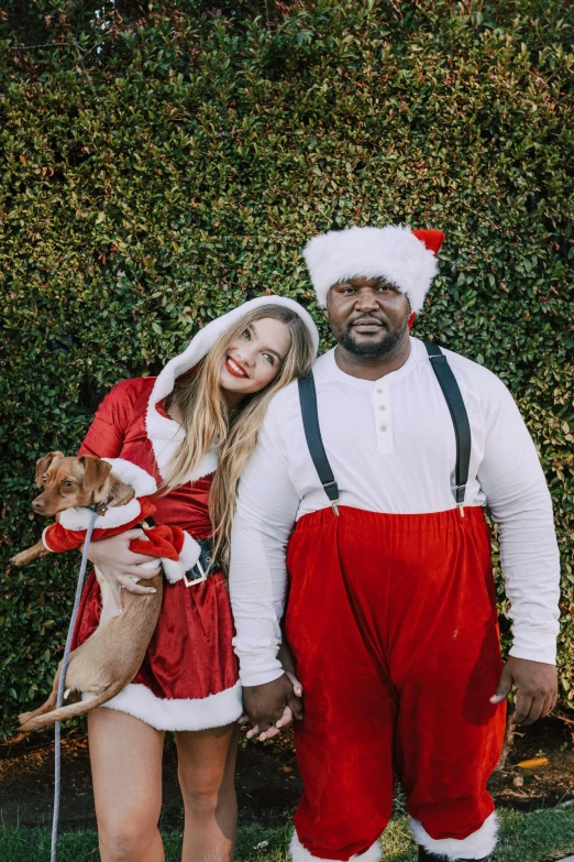 a man and woman dressed as santa claus and a dog, an album cover, by Sara Saftleven, pexels, shaq, avacado halloween costumes, bella thorne, an obese