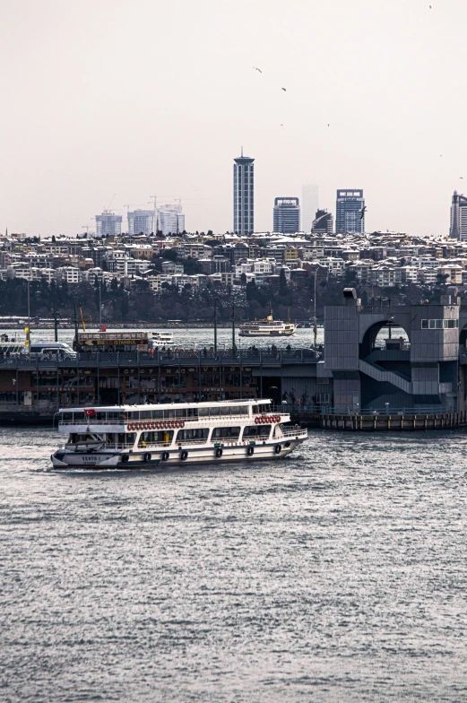 a couple of boats that are in the water, by Nabil Kanso, tall bridge with city on top, istanbul, slide show, 2022 photograph