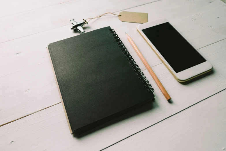 a notebook, pencil, and cell phone on a table, by Robbie Trevino, trending on pexels, black canvas, 9 9 designs, full body image, black and brown