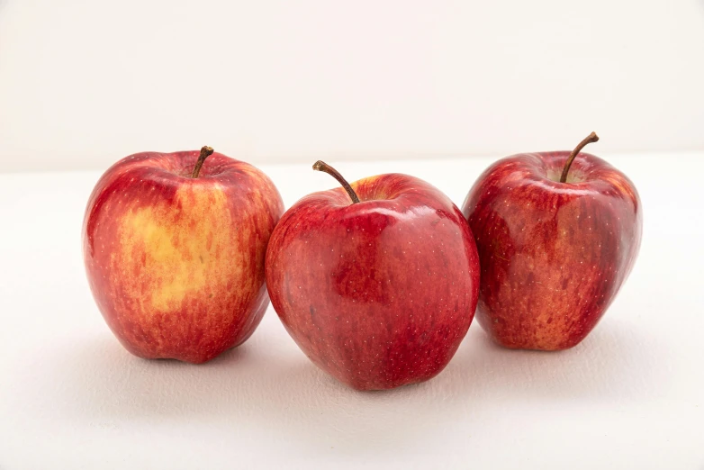 three apples sitting next to each other on a table, medium wide front shot, 6 pack, red, portrait n - 9