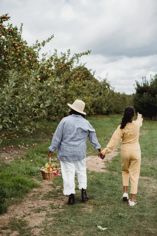 two people walking through an apple orchard holding hands, by Jessie Algie, pexels contest winner, wearing farm clothes, summer day, inspect in inventory image, holiday