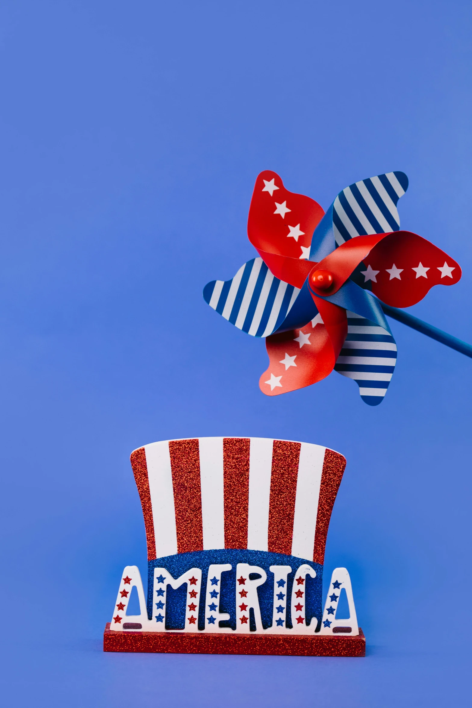 a red, white and blue top hat with a pinwheel, by Bernie D’Andrea, trending on unsplash, toys, american propaganda, show from below, 🚿🗝📝