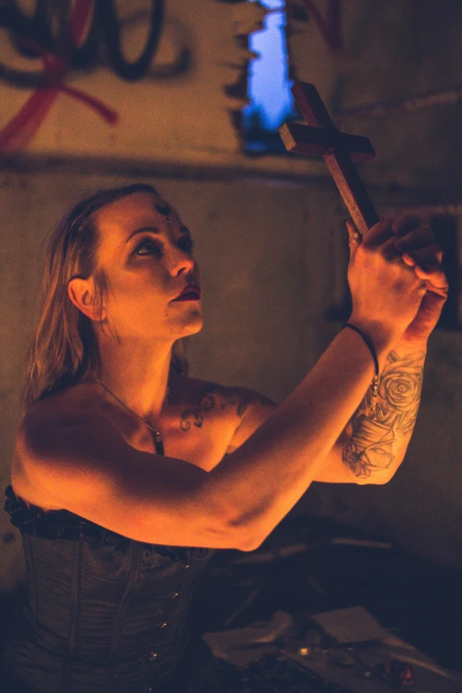 a woman holding a knife in a dark room, runic tattoos, holding wood saw, ( ( theatrical ) ), profile image