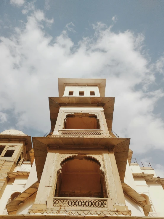 a tall building with a clock on top of it, inspired by Frederick Goodall, trending on unsplash, renaissance, khajuraho, shot on gopro9, low quality photo, mid view from below her feet