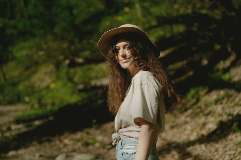 a woman in a hat poses for a picture, pexels contest winner, lorde, near forest, wearing a linen shirt, shot on superia 400 filmstock