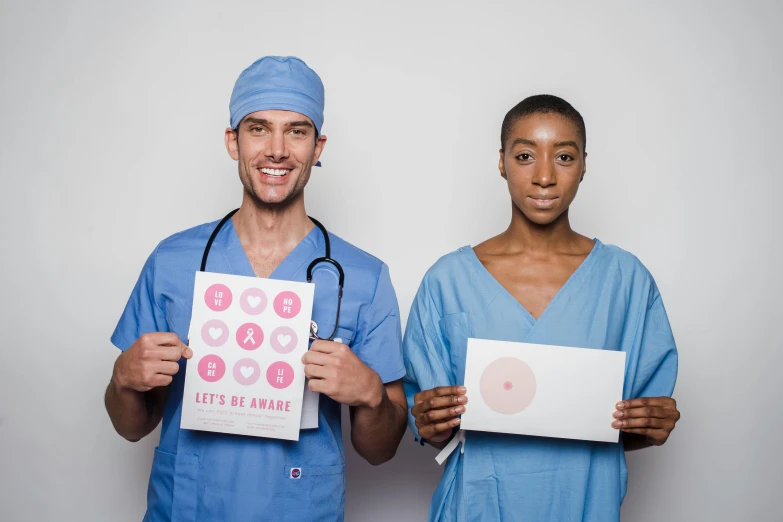 a man and a woman in scrubs holding up signs, pexels contest winner, pink scheme, beautiful people, medical image, 15081959 21121991 01012000 4k