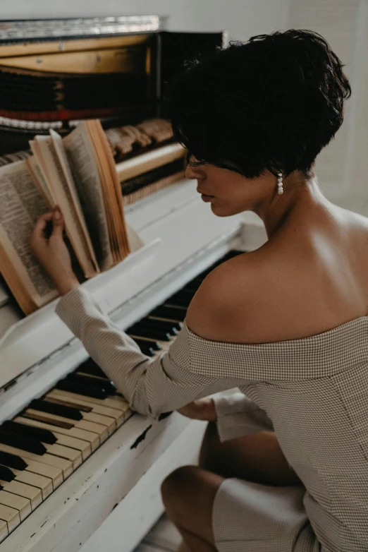 a woman sitting on the floor playing a piano, an album cover, pexels contest winner, baroque, wearing white leotard, candid shot, alessio albi, an elegant