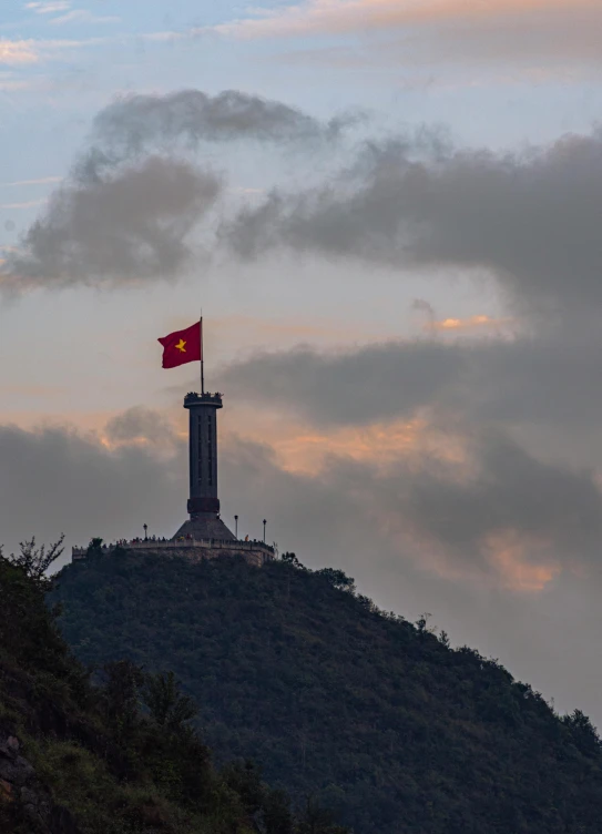 a hill with a flag on top of it, a statue, vietnam, profile image, square, low quality photo