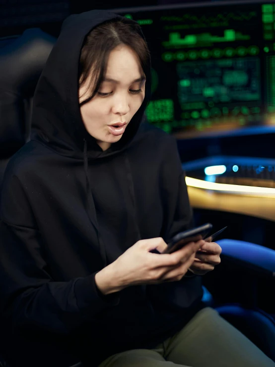 a woman in a black hoodie texting on a cell phone, happening, led gaming, avatar image, multiple stories, crypto