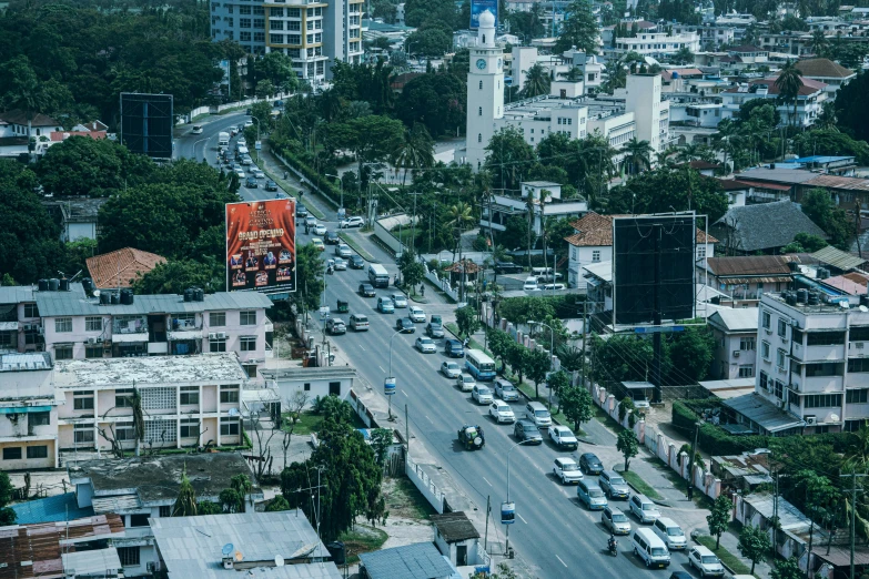 a city filled with lots of traffic next to tall buildings, by Ella Guru, hurufiyya, billboard image, photograph from above, outdoors tropical cityscape, historical image