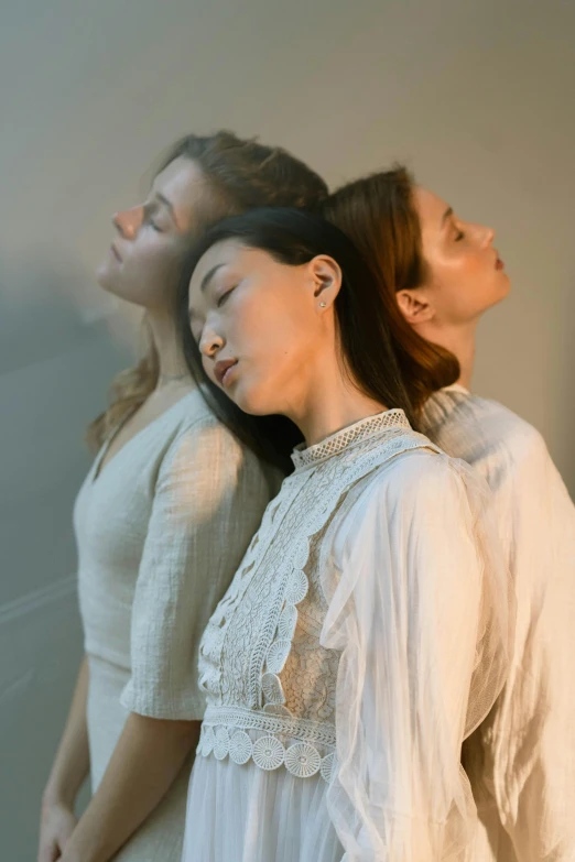 a couple of women standing next to each other, inspired by Fei Danxu, trending on unsplash, aestheticism, asleep, three heads, “ ethereal, laying on their back