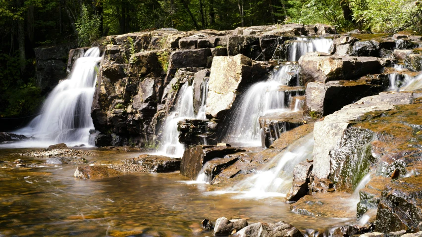 a waterfall flowing through a lush green forest, unsplash, hudson river school, boulders, splash image, new hampshire, 2000s photo