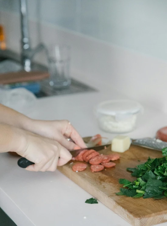 a person chopping up vegetables on a cutting board, sausages, taejune kim, dwell, during the day