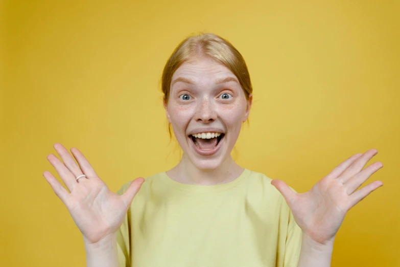 a woman making a funny face with her hands, pexels contest winner, all overly excited, yellow skin, avatar image, teenage girl