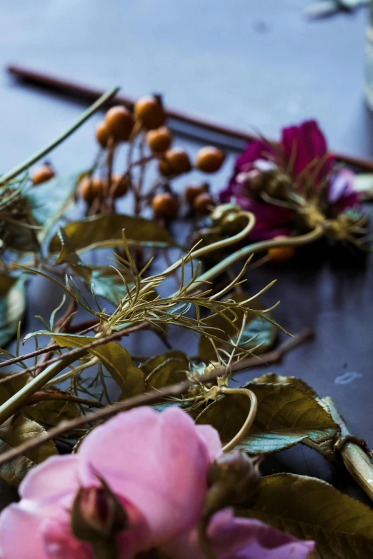 a bunch of flowers sitting on top of a table, a still life, process art, dried vines, close - up photograph, ingredients on the table, foliage