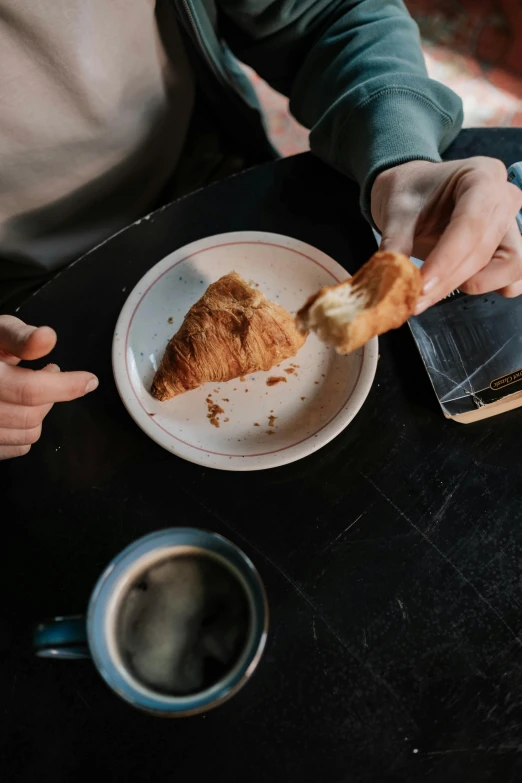 a person sitting at a table with a plate of food, by Daniel Seghers, trending on unsplash, bakery, spilt coffee, cone shaped, long sleeves