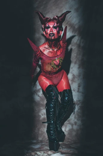 a woman in a devil costume posing for a picture, an album cover, featured on zbrush central, transgressive art, wearing war paint, blood and body parts, bodypaint, taken in 2 0 2 0